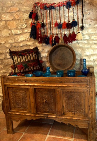 An ornate hand carved wooden sideboard displaying blue bowls and jugs from Pakistan's North-West Frontier