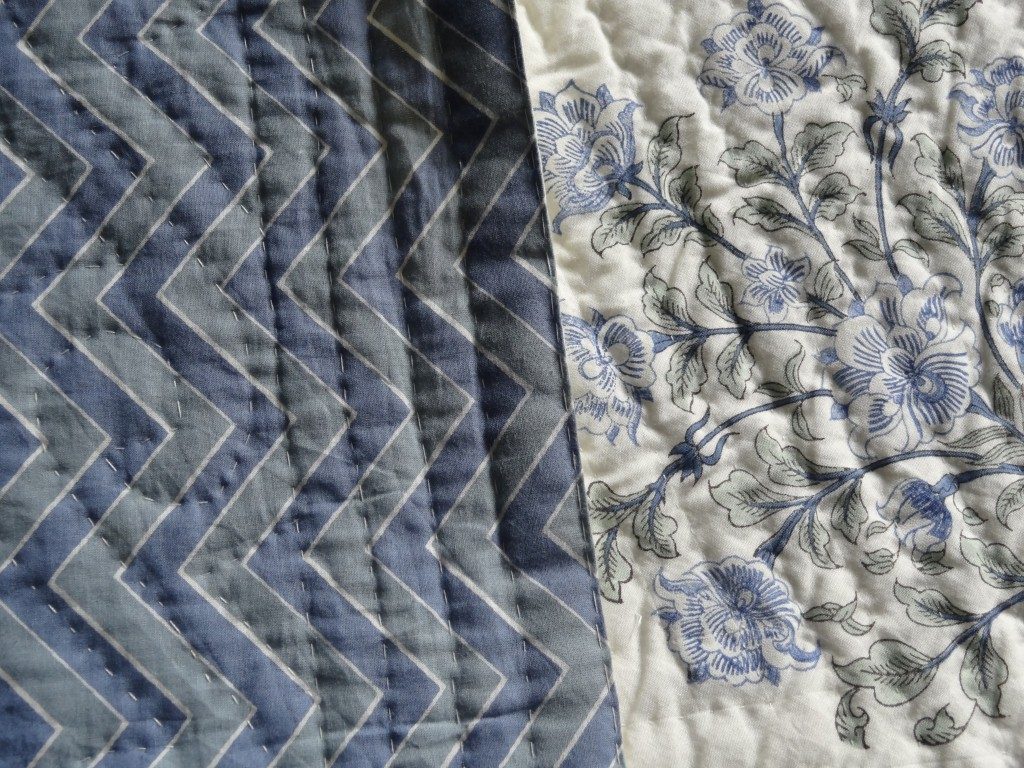Cream and blue quilted bedspread with zig-zag design on the reverse